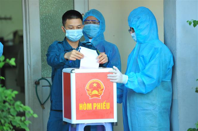 Các cử tri làm nhiệm vụ tại Khu cách ly tập trung, bỏ phiếu bầu tại đơn vị bầu cử số 7, phường Trang Hạ, thị xã Từ Sơn, Bắc Ninh. Ảnh: Minh Đức - TTXVN 16 tỉnh, thành phố hoàn thành việc bầu cử sớm ảnh 4