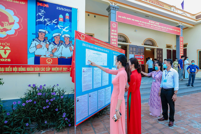 Các nữ cử tri xem danh sách đại biểu. Ảnh: Lưu Cường Những tà áo dài trong ngày bầu cử ảnh 2