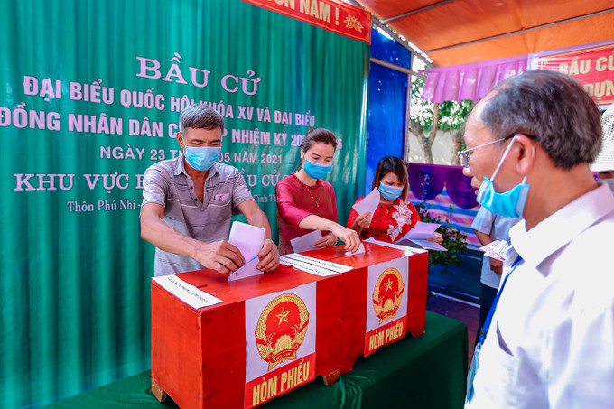 Tự tay bỏ phiếu bầu đại biểu. Ảnh: Lưu Cường Những tà áo dài trong ngày bầu cử ảnh 5