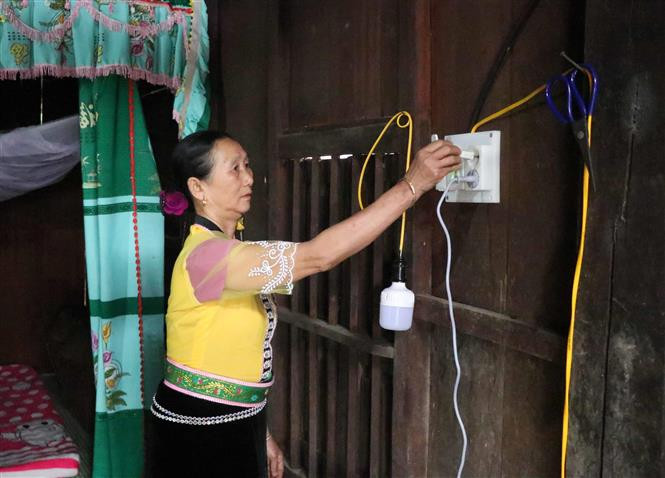 Người dân bản Yên (xã Mường Toong, huyện Mường Nhé, tỉnh Điện Biên) sử dụng điện lưới quốc gia. Ảnh: Xuân Tiến- TTXVN Điện về bản Yên bừng sáng sau hơn 30 năm mong đợi ảnh 2
