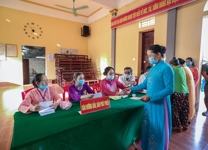 Các nữ cử tri duyên dáng trong tà áo dài truyền thống đến làm thủ tục bỏ phiếu. Ảnh: Lưu Cường Những tà áo dài trong ngày bầu cử ảnh 4