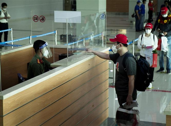 Du khách Hàn Quốc làm thủ tục nhập cảnh. Ảnh: Hồng Đạt - TTXVN Kiên Giang đón đoàn du khách quốc tế "hộ chiếu vaccine" đầu tiên đến Phú Quốc ảnh 1