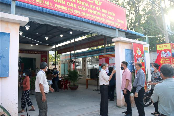 Tại các điểm bỏ phiếu, cử tri bắt buộc phải đeo khẩu trang và được đo thân nhiệt trước khi vào bỏ phiếu. Ảnh: Nguyễn Thanh - TTXVN Ngày hội non sông trên quê hương Bác ảnh 1