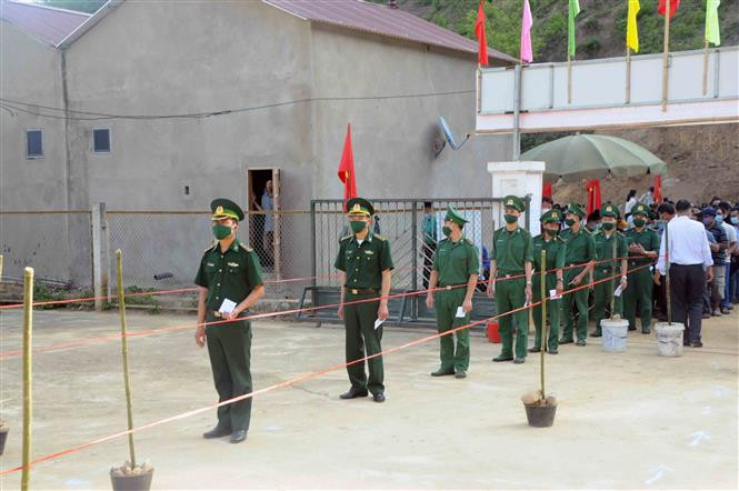 Đến các điểm bầu cử, cử tri đeo khẩu trang, rửa tay sát khuẩn, đo thân nhiệt, giữ khoảng cách an toàn trước khi vào khu vực bỏ phiếu, đảm bảo công tác phòng, chống dịch COVID-19. Ảnh: Quang Quyết - TTXVN Tưng bừng Ngày Bầu cử ở vùng cao Sơn La ảnh 2