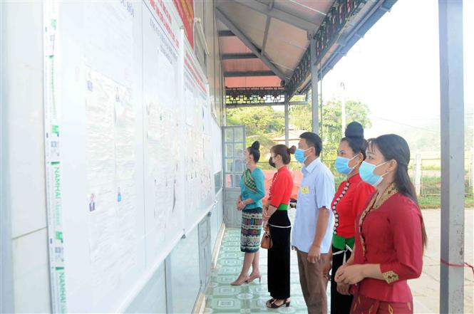 Cử tri các dân tộc bản Mường Lạn, xã Mường Lạn xem tiểu sử tóm tắt các đại biểu tham gia ứng cử để bầu cử. Ảnh: Quang Quyết - TTXVN Tưng bừng Ngày Bầu cử ở vùng cao Sơn La ảnh 4