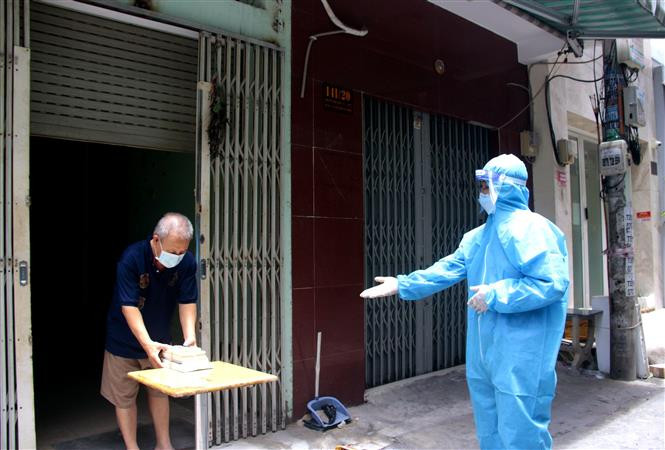 Người dân trong khu cách ly, phong tỏa ở Thành phố Hồ Chí Minh được quan tâm phát sách để đọc trong thời gian thực hiện cách ly tại nhà. Ảnh: Thành Chung - TTXVN Thành phố Hồ Chí Minh thí điểm ứng dụng công nghệ quản lý, giám sát cách ly tại nhà ảnh 1