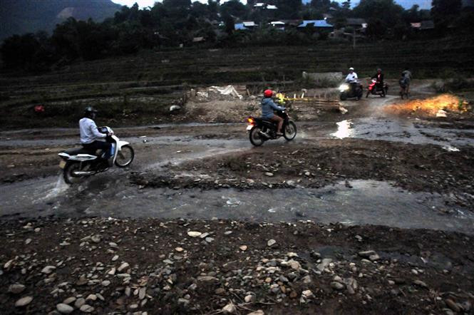 Để tới các điểm trường thuộc Trường Tiểu học Mường Bám II, thầy cô đi gần 1 tiếng đồng hồ bằng xe máy băng qua những con suối, đường đất, dốc cao cheo leo bên vách núi. Ảnh: Quang Quyết - TTXVN Những giáo viên tâm huyết “cõng chữ” lên bản làng ở Sơn La ảnh 1