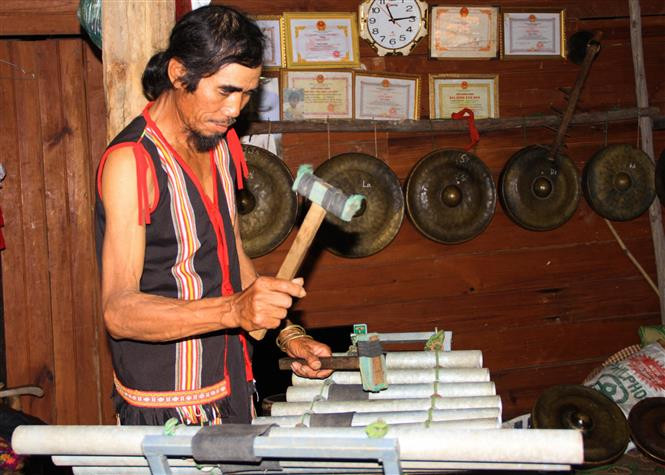 Ông A Thui biểu diễn chiếc đàn T’rưng sắt do chính ông chế tác. Ảnh: Khoa Chương - TTXVN A Thui - Người giữ hồn văn hóa Rơ Ngao ảnh 3