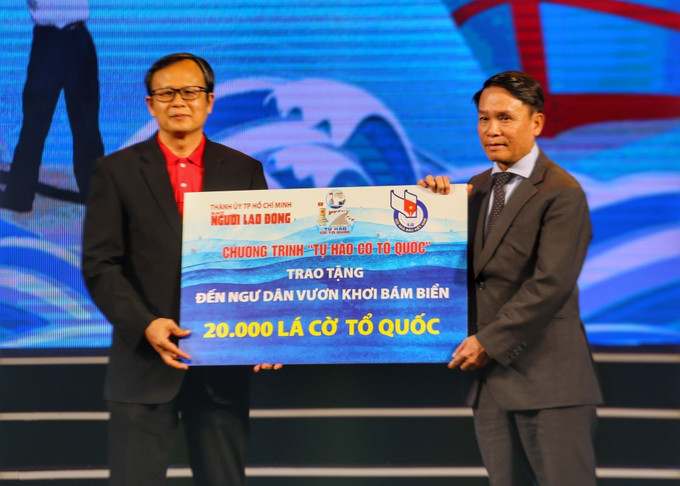 Báo Người lao động trao 20.000 lá cờ Tổ quốc cho Hội Nhà báo Việt Nam để tặng cho các ngư dân. Ảnh: Tuấn Đức - TTXVN Xúc động Chương trình giao lưu nghệ thuật “Trái tim biển đảo” ảnh 1