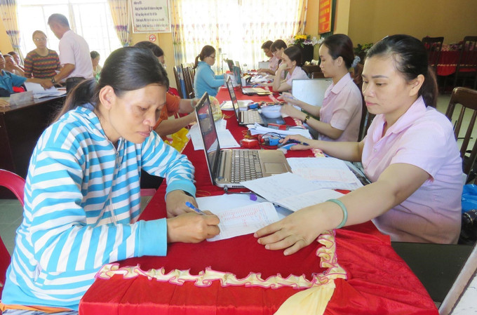 Cán bộ Ngân hàng Chính sách xã hội tỉnh Phú Yên giải ngân cho các hộ dân người đồng bào miền núi Phú Yên vay vốn theo Nghị định 28. Ảnh: TTXVN phát Trao cơ hội thoát nghèo cho đồng bào miền núi từ vốn vay ưu đãi ở Phú Yên ảnh 2