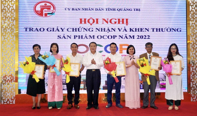 Ông Hà Sỹ Đồng, Phó Chủ tịch Thường trực UBND tỉnh Quảng Trị trao giấy chứng nhận sản phẩm OCOP 4 sao năm 2022 cho các hộ sản xuất kinh doanh. Ảnh: Nguyên Linh - TTXVN Quảng Trị khuyến khích phát triển sản phẩm gắn với du lịch ảnh 1
