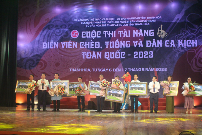 Ban tổ chức tặng hoa cho đại diện các đơn vị nghệ thuật có diễn viên tham gia cuộc thi. Ảnh: Hoa Mai - TTXVN Khai mạc cuộc thi tài năng diễn viên Chèo, Tuồng và Dân ca kịch toàn quốc ảnh 4