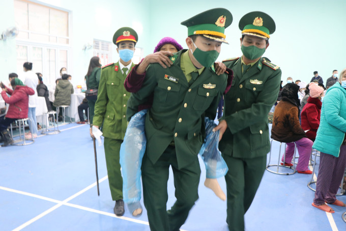 Những cụ già sức khỏe yếu được các cán bộ, chiến sĩ biên phòng hỗ trợ tận tình. Ảnh: Tường Vi - TTXVN Mang Tết đầm ấm đến với vùng cao Thừa Thiên - Huế ảnh 3