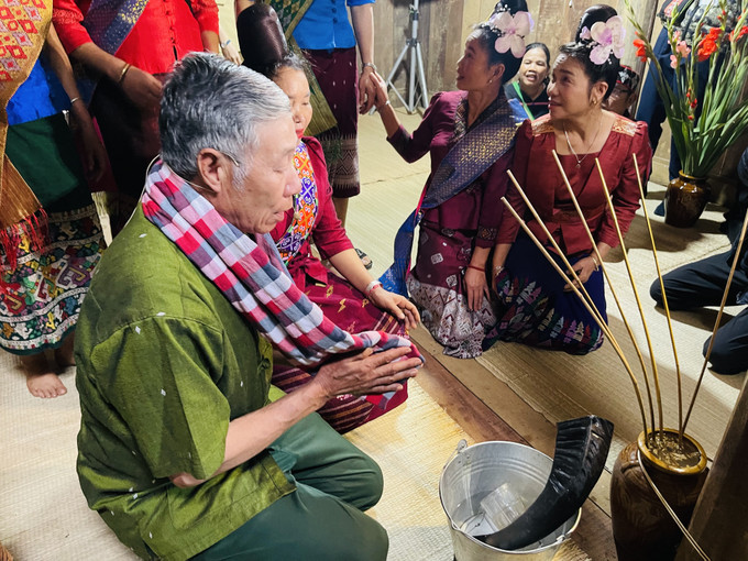 Chủ lễ tiến hành nghi lễ uống rượu cần để bà con chuẩn bị vui hội đem lại may mắn trong ngôi nhà mới. Ảnh: Hoàng Tâm Đặc sắc lễ vào nhà mới của đồng bào dân tộc Lào ảnh 10