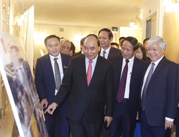 Chủ tịch nước Nguyễn Xuân Phúc và các đại biểu xem trưng bày ảnh. Ảnh: Thống Nhất – TTXVN Chủ tịch nước dự lễ tôn vinh 100 Nông dân Việt Nam xuất sắc năm 2022 ảnh 5