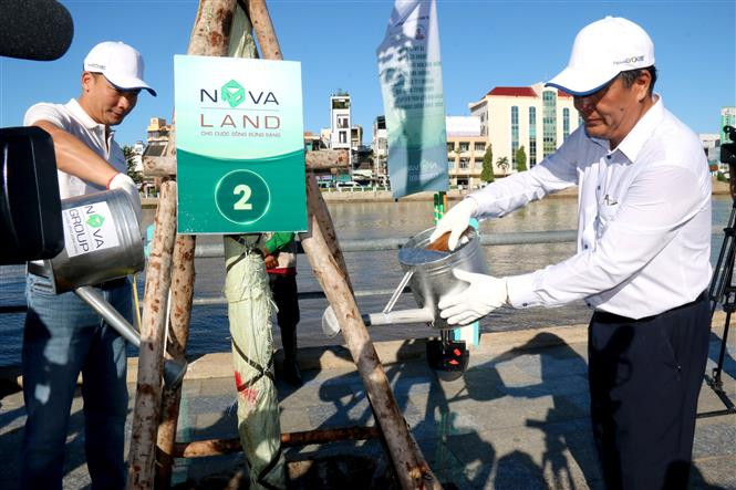 Đại biểu trồng và chăm sóc cây xanh dọc theo bờ sông Cà Ty, thành phố Phan Thiết (Bình Thuận). Ảnh: Nguyễn Thanh - TTXVN Triển khai trồng 10 triệu cây xanh bảo vệ môi trường trên địa bàn tỉnh Bình Thuận ảnh 1