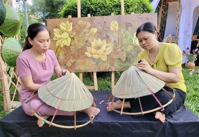 Biểu diễn nghề truyền thống nón lá làm từ sen tại ngày hội. Ảnh: Mai Trang - TTXVN Khai mạc Ngày hội Sen Huế 2022 - Tinh hoa của đất trời ảnh 3
