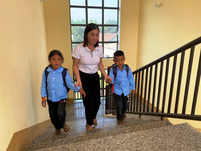 Cô Thưu đưa các em học sinh dân tộc Chứt đến trường. Ảnh: Hoàng Ngà - TTXVN Cô giáo Hoàng Thị Thưu, người mẹ thứ hai của học sinh dân tộc Chứt ảnh 1