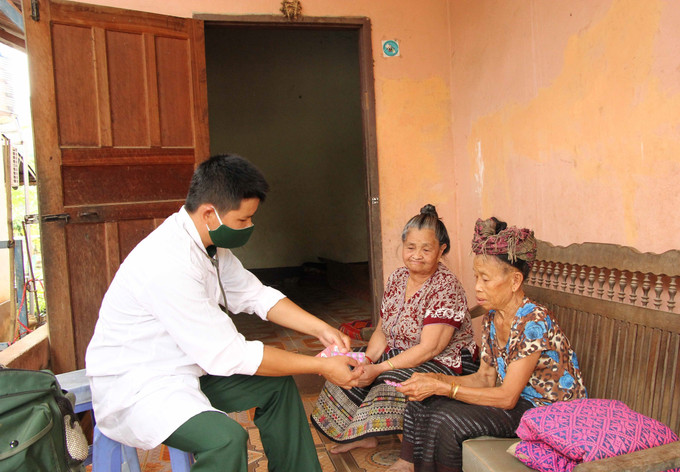 Cán bộ quân y Đồn Biên phòng Cửa khẩu Chiềng Khương, Bộ Chỉ huy Bộ đội Biên phòng tỉnh Sơn La khám chữa bệnh, cấp phát thuốc miễn phí cho người dân bản Đán, huyện Mường Ét, tỉnh Hủa Phăn (Lào). Ảnh: Nguyễn Cường - TTXVN Sơn La hợp tác toàn diện với nhiều tỉnh của Lào ảnh 1