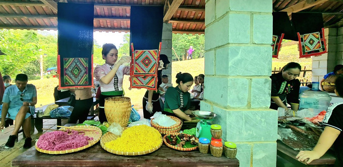Đồng bào dân tộc Thái giới thiệu món xôi ngũ sắc tại chợ vùng cao. Ảnh: Hoàng Tâm “Món ngon vùng miền - Chào xuân 2023”, chủ đề tháng 12 tại Làng Văn hóa - Du lịch các dân tộc Việt Nam ảnh 1