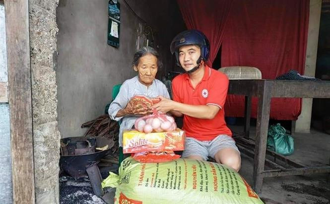 Các tình nguyện viên Hội Chữ thập đỏ tỉnh Quảng Bình trao tặng quà hỗ trợ các đối tượng già cả, neo đơn, chính sách... trên địa bàn xã An Thủy, huyện Lệ Thủy, Quảng Bình bị ảnh hưởng do mưa lũ. Ảnh: TTXVN phát Sẻ chia khó khăn với người dân vùng lũ tỉnh Quảng Bình ảnh 3