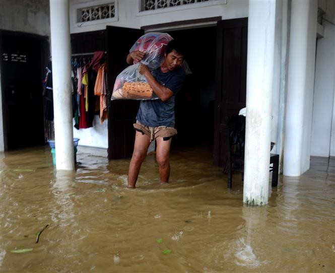 Người dân di dời đồ đạc đến vị trí cao ráo để tránh lũ. Ảnh: Lê Ngọc Phước - TTXVN Bão số 6 trên đất liền các tỉnh Quảng Nam, Quảng Ngãi suy yếu thành áp thấp nhiệt đới ảnh 1