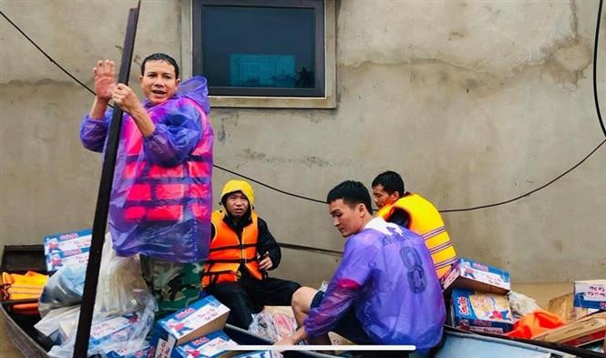 Đội thuyền cứu trợ của anh Phạm Đình Hòa, trưởng thôn Sơn Trình, xã Tân Lâm Hương, huyện Thạch Hà (Hà Tĩnh) tiếp tế cho người dân trong mưa lũ. Ảnh: TTXVN phát Những cán bộ cơ sở quên mình giúp dân trong mưa lũ ảnh 2