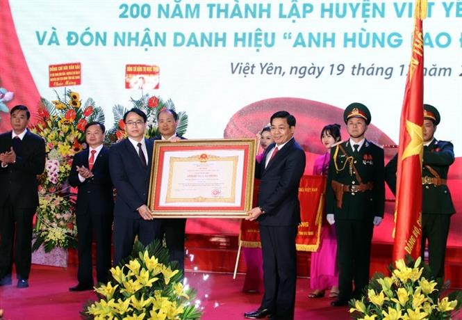 Thừa ủy quyền của Chủ tịch nước, Bí thư Tỉnh ủy Bắc Giang Dương Văn Thái trao Danh hiệu Anh hùng Lao động thời kỳ đổi mới cho Đảng bộ, chính quyền và nhân dân huyện Việt Yên. Ảnh: Đồng Thúy-TTXVN Huyện Việt Yên đón nhận danh hiệu Anh hùng Lao động thời kỳ đổi mới ảnh 1