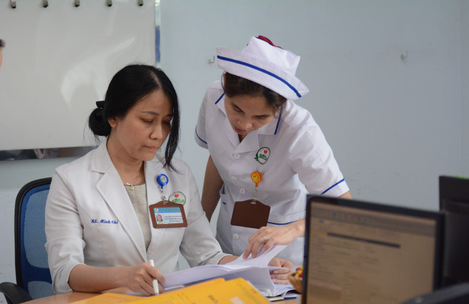 Bác sĩ Nguyễn Thị Minh Chí trao đổi công việc với nhân viên y tế. Ảnh: Văn Dũng-TTXVN potal-nu-bac-si-tan-tam-diem-tua-tinh-than-cho-benh-nhan-ung-thu-vu-7901246.jpg