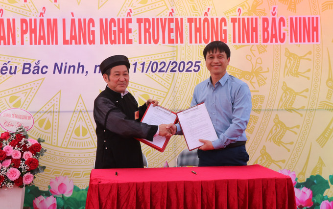 Đại diện Câu lạc bộ Thư pháp Bắc Ninh ký thỏa thuận hợp tác với Trung tâm Bảo tồn Di tích và xúc tiến du lịch của tỉnh. Ảnh: Thanh Thương- TTXVN potal-trung-bay-san-pham-lang-nghe-truyen-thong-quang-ba-du-lich-tinh-bac-ninh-7850873.jpg