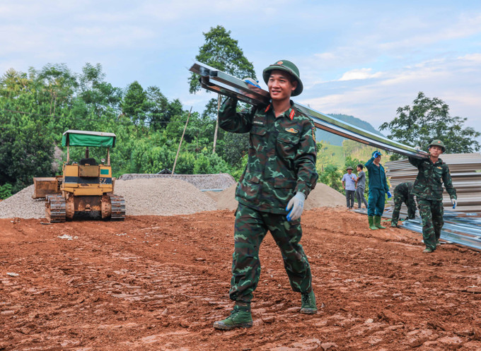 Lực lượng quân đội tham gia hỗ trợ xây dựng khu nhà ở tạm thời cho người dân thôn Làng Nủ. Ảnh: Hoàng Hiếu - TTXVN potal-lao-cai-se-ban-giao-25-can-nha-tam-cho-nguoi-dan-thon-lang-nu-trong-ngay-219-7606104.jpg
