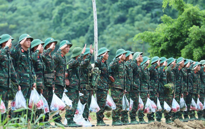 Các chiến sĩ thuộc Trung đoàn 98, Sư đoàn 316 chào bà con nhân dân thôn Làng Nủ trước khi về đơn vị. Ảnh: TTXVN potal-luc-luong-quan-khu-2-rut-khoi-thon-lang-nu-7614390.jpg