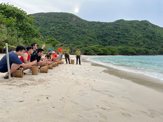 Du khách trải nghiệm tour du lịch sinh thái và trải nghiệm xem rùa đẻ trứng, thả rùa con về môi trường tự nhiên. Ảnh: TTXVN phát potal-50-nam-thong-nhat-dat-nuoc-con-dao-nua-the-ky-mot-hanh-trinh-phat-trien-7989018.jpg