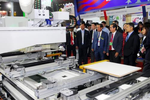 Các đại biểu tham quan các gian hàng về máy móc thiết bị chế biến gỗ. Ảnh: Mạnh Linh-TTXVN