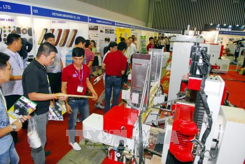 Khách tham quan các gian hàng về máy móc thiết bị chế biến gỗ. Ảnh: Mạnh Linh-TTXVN
