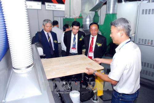 Khách tham quan các gian hàng về máy móc thiết bị chế biến gỗ. Ảnh: Mạnh Linh-TTXVN