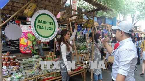 Các bạn trẻ chụp hình lưu niệm tại gian hàng bánh Tét trên Đường sách Nguyễn Văn Bình. Ảnh: Gia Thuận - TTXVN Các bạn trẻ chụp hình lưu niệm tại gian hàng bánh Tét trên Đường sách Nguyễn Văn Bình. Ảnh: Gia Thuận - TTXVN