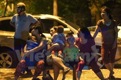 Nhiều gia đình không dám về nhà, phải ngủ lại bên ngoài vì sợ đám cháy tiếp tục xảy ra. (Ảnh: PV/Vietnam+)