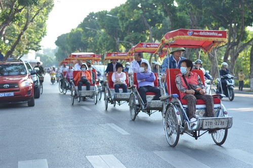 Giữa phố xá đông đúc, những chiếc xích lô vẫn lăn bánh thật chậm rãi.