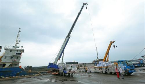 Bốc xếp hàng lên tàu tại cảng PTSC Dung Quất. Ảnh: Huy Hùng – TTXVN Bốc xếp hàng lên tàu tại cảng PTSC Dung Quất. Ảnh: Huy Hùng – TTXVN