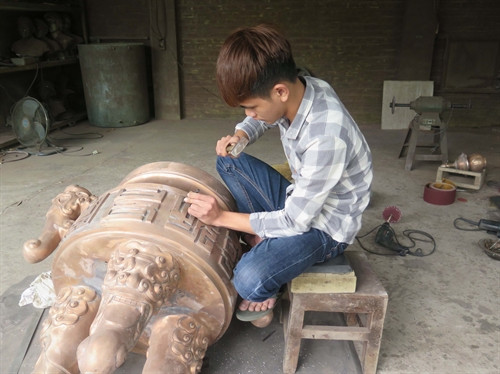 Một sản phẩm đang được người thợ làng nghề thực hiện sửa nguội, đục âm để khảm đồng.