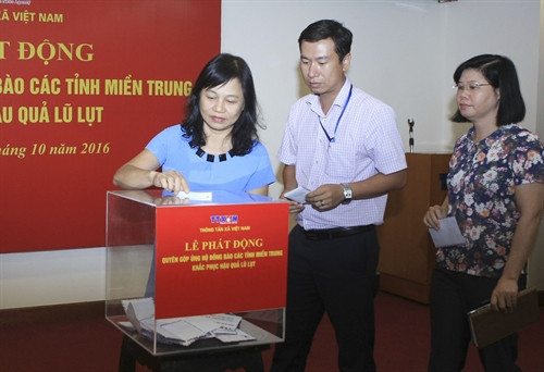 Cán bộ, phóng viên, biên tập viên và người lao động Thông tấn xã Việt Nam tại Hà Nội ủng hộ đồng bào các tỉnh miền Trung khắc phục hậu quả lũ lụt. Ảnh: Phạm Kiên – TTXVN