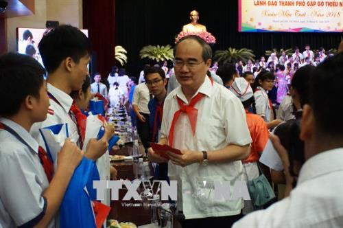 Đồng chí Nguyễn Thiện Nhân, Ủy viên Bộ Chính trị, Bí thư Thành ủy Thành phố Hồ Chí Minh lì xì năm mới cho các thiếu nhi tiêu biểu tham dự chương trình. Ảnh: Thu Hoài - TTXVN