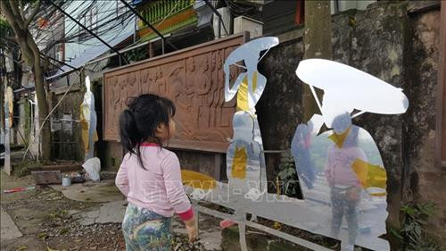 Tác phẩm sắp đặt những gánh hàng rong, những người lao động ở bến sông Hồng và 2 bức phù điêu của nghệ sĩ Nguyễn Thế Sơn. Ảnh: TTXVN Tác phẩm sắp đặt những gánh hàng rong, những người lao động ở bến sông Hồng và 2 bức phù điêu của nghệ sĩ Nguyễn Thế Sơn. Ảnh: TTXVN