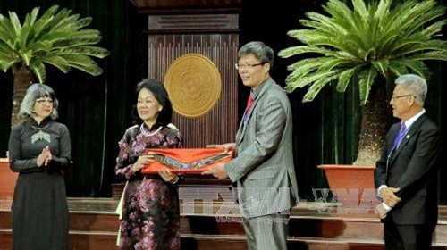 Đồng chí Trương Thị Mai, Ủy viên Bộ Chính trị, Bí thư Trung ương Đảng, Trưởng Ban Dân vận Trung ương nhận quà lưu niệm từ đại diện cộng đồng kiều bào Việt Nam toàn thế giới tại phiên khai mạc hội nghị