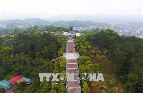 Dẫn lên Tượng đài Chiến thắng lịch sử Điện Biên Phủ là Trục hành lễ gồm 320 bậc, được chia làm 3 chiếu nghỉ lớn, tương đương với 3 đợt tấn công của Quân đội ta vào Tập đoàn cứ điểm Điện Biên Phủ. Hai bên trục hành lễ là 56 cột mốc được làm bằng đá xanh tượng trưng cho 56 ngày đêm “khoét núi, ngủ hầm, mưa dầm, cơm vắt” của bộ đội ta. Hai bên sườn đồi dọc trục hành lễ được trồng cây hoa Ban và một số cây khác tạo cảnh quan thiên nhiên và môi trường cho đồi di tích này. Ảnh: Xuân Tiến-TTXVN