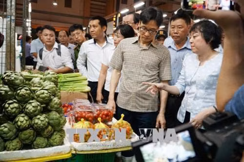 Phó thủ tướng Chính Phủ Vũ Đức Đam cùng đoàn công tác thị sát tình hình kinh doanh buôn bán của bà con tiểu thương và công tác đảm bảo an toàn vệ sinh thực phẩm tại chợ đầu mối Bình Điền, Thành phố Hồ Chí Minh. Ảnh: Phương Vy-TTXVN