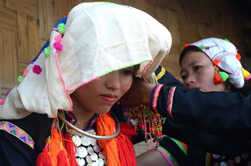 Các thiếu nữ Si La trong trang phục truyền thống. Để tôn nên vẻ đẹp của mình, các thiếu nữ Si La sử dụng thêm các chuỗi hạt cườm, các họa tiết trang trí nhiều màu sắc. Các vòng trang sức gắn bạc, đồng tạo nên nét độc đáo trong trang phục dân tộc người Si La. Trang phục Si La còn phản ánh các giá trị tôn giáo, tín ngưỡng, vị trí xã hội người mặc. Với phụ nữ Si La chiếc khăn đội đầu thể hiện lứa tuổi, tình trạng hôn nhân như: khăn trắng dành cho người chưa lập gia đình; khăn đen người đã có gia đình. Trên thân áo Pi Khồ của phụ nữ Si La được đính 72 đồng xu bạc thành 9 hàng ngang, giữa hàng xu bạc có trang trí các đường hoa văn kẻ bằng chỉ đỏ, thể hiện tín ngưỡng tâm linh của đồng bào. Trang phục truyền thống người đàn ông Si La với sự giản dị, mộc mạc và khỏe khoắn. Chiếc khăn “dơ phừ” do mẹ chồng khâu là một kỷ vật thiêng liêng gắn bó với mỗi người con gái Si La khi về nhà chồng. Nét độc đáo của chiếc khăn “dơ phừ” là đầu khăn được khâu thành chiếc túi, sau đó tạo thành một cuốn tóc lớn vấn ngang trên trán. Nếu cuốn tóc này chưa đủ to thì phải độn thêm tóc của chồng. Điều này thể hiện tín ngưỡng về tình yêu, tình cảm vợ chồng son sắt, thủy chung gắn bó của người Si La. Đồng bào có nền văn hóa đa dạng, nguyên bản và phong phú như: hát giao duyên giữa nam nữ thanh niên, hát sử ca. Ngày tết năm mới vào đầu tháng 12 âm lịch. Ngoài ra họ còn ăn tết cơm mới. Các em nhỏ Si La thường chơi các đồ chơi tự chế từ tre gỗ hay đất sét. Đồng thời, chúng cũng có các trò chơi tập thể rất vui nhộn. Cùng sự giao thoa văn hoá với các dân tộc khác, trang phục truyền thống lại cầu kỳ nên người Si La sử dụng trang phục này chủ yếu vào các dịp lễ tết, cưới hỏi, các sự kiện lớn bản làng... góp phần bảo tồn bản sắc của người Si La, và gìn giữ một nét đẹp độc đáo trong vườn hoa văn hoá cộng đồng các dân tộc Việt Nam. Các thiếu nữ Si La trong trang phục truyền thống. Để tôn nên vẻ đẹp của mình, các thiếu nữ Si La sử dụng thêm các chuỗi hạt cườm, các họa tiết trang trí nhiều màu sắc. Các vòng trang sức gắn bạc, đồng tạo nên nét độc đáo trong trang phục dân tộc người Si La. Trang phục Si La còn phản ánh các giá trị tôn giáo, tín ngưỡng, vị trí xã hội người mặc. Với phụ nữ Si La chiếc khăn đội đầu thể hiện lứa tuổi, tình trạng hôn nhân như: khăn trắng dành cho người chưa lập gia đình; khăn đen người đã có gia đình. Trên thân áo Pi Khồ của phụ nữ Si La được đính 72 đồng xu bạc thành 9 hàng ngang, giữa hàng xu bạc có trang trí các đường hoa văn kẻ bằng chỉ đỏ, thể hiện tín ngưỡng tâm linh của đồng bào. Trang phục truyền thống người đàn ông Si La với sự giản dị, mộc mạc và khỏe khoắn. Chiếc khăn “dơ phừ” do mẹ chồng khâu là một kỷ vật thiêng liêng gắn bó với mỗi người con gái Si La khi về nhà chồng. Nét độc đáo của chiếc khăn “dơ phừ” là đầu khăn được khâu thành chiếc túi, sau đó tạo thành một cuốn tóc lớn vấn ngang trên trán. Nếu cuốn tóc này chưa đủ to thì phải độn thêm tóc của chồng. Điều này thể hiện tín ngưỡng về tình yêu, tình cảm vợ chồng son sắt, thủy chung gắn bó của người Si La. Đồng bào có nền văn hóa đa dạng, nguyên bản và phong phú như: hát giao duyên giữa nam nữ thanh niên, hát sử ca. Ngày tết năm mới vào đầu tháng 12 âm lịch. Ngoài ra họ còn ăn tết cơm mới. Các em nhỏ Si La thường chơi các đồ chơi tự chế từ tre gỗ hay đất sét. Đồng thời, chúng cũng có các trò chơi tập thể rất vui nhộn. Cùng sự giao thoa văn hoá với các dân tộc khác, trang phục truyền thống lại cầu kỳ nên người Si La sử dụng trang phục này chủ yếu vào các dịp lễ tết, cưới hỏi, các sự kiện lớn bản làng... góp phần bảo tồn bản sắc của người Si La, và gìn giữ một nét đẹp độc đáo trong vườn hoa văn hoá cộng đồng các dân tộc Việt Nam.