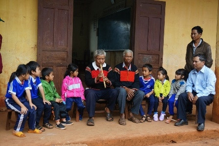 Nghệ nhân Y Bruăt thổi Đing buốt giao lưu với thanh thiếu nhi trong buôn