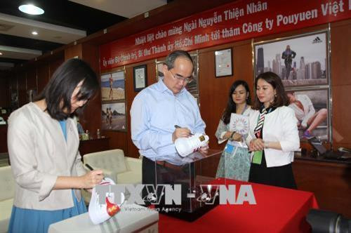 Bí thư Thành ủy Thành phố Hồ Chí Minh Nguyễn Thiện Nhân và bà Thái Bội Quân, Chủ tịch kiêm Tổng Giám đốc điều hành Tập đoàn Pou Yuen ký lưu niệm lên sản phẩm của Công ty TNHH Pou Yuen Việt Nam. Ảnh: Thanh Vũ-TTXVN